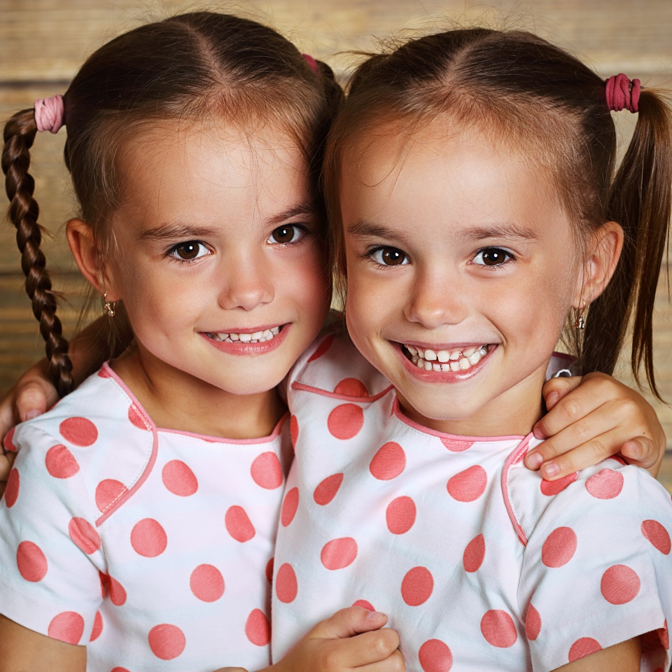happy family children twin sisters hugging and laughing