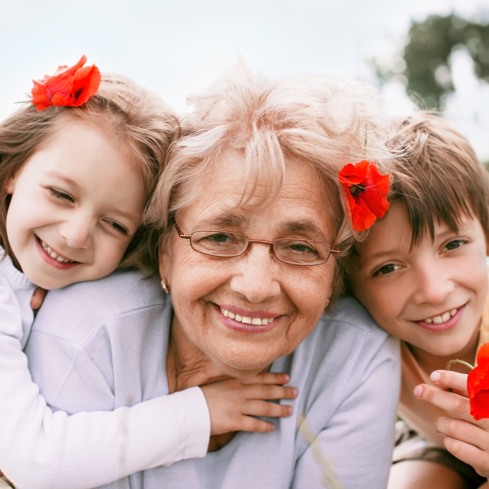 Closeup summer portrait of happy grandmother with grandchildren outdoors