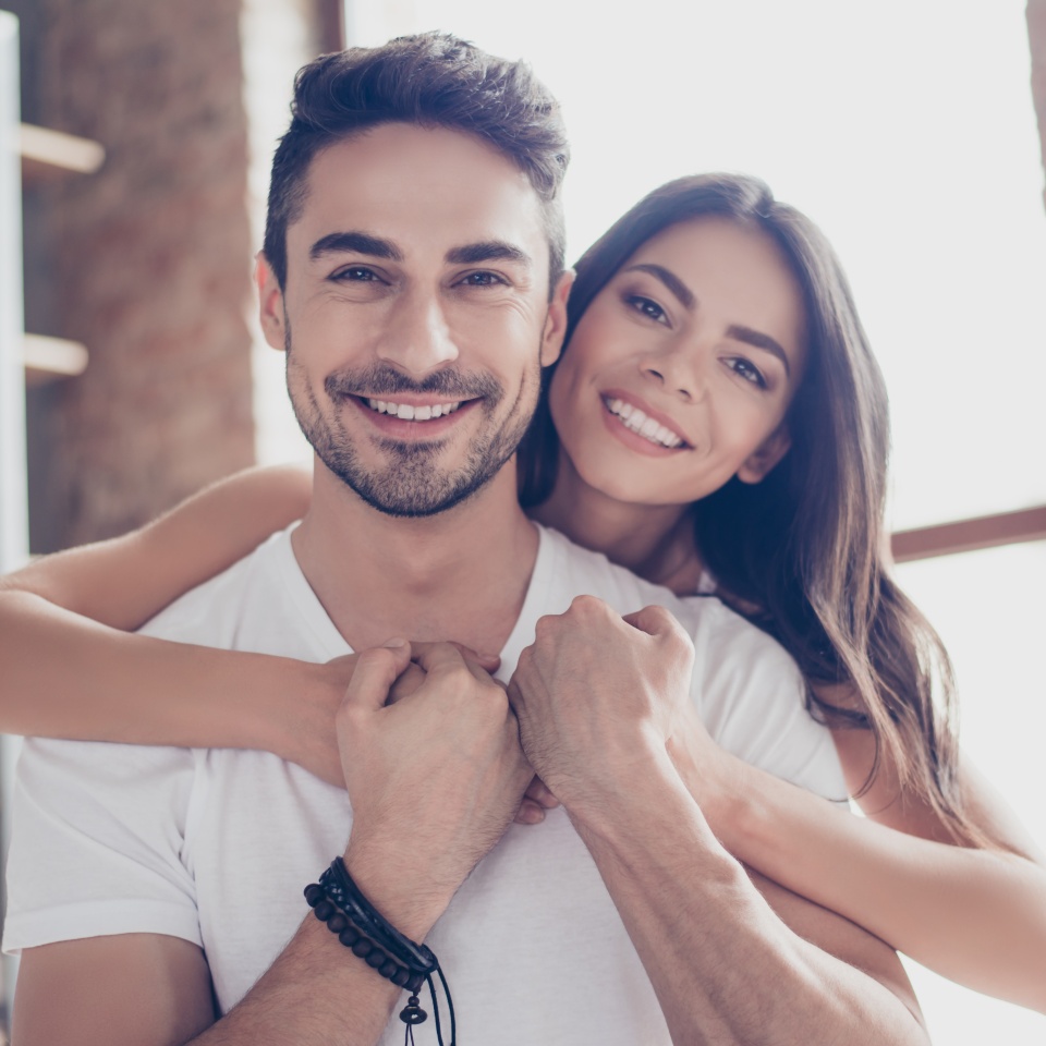 True love. Beautiful latino couple of young lovers are hugging indoors at home with love and tenderness wearing casual clothes